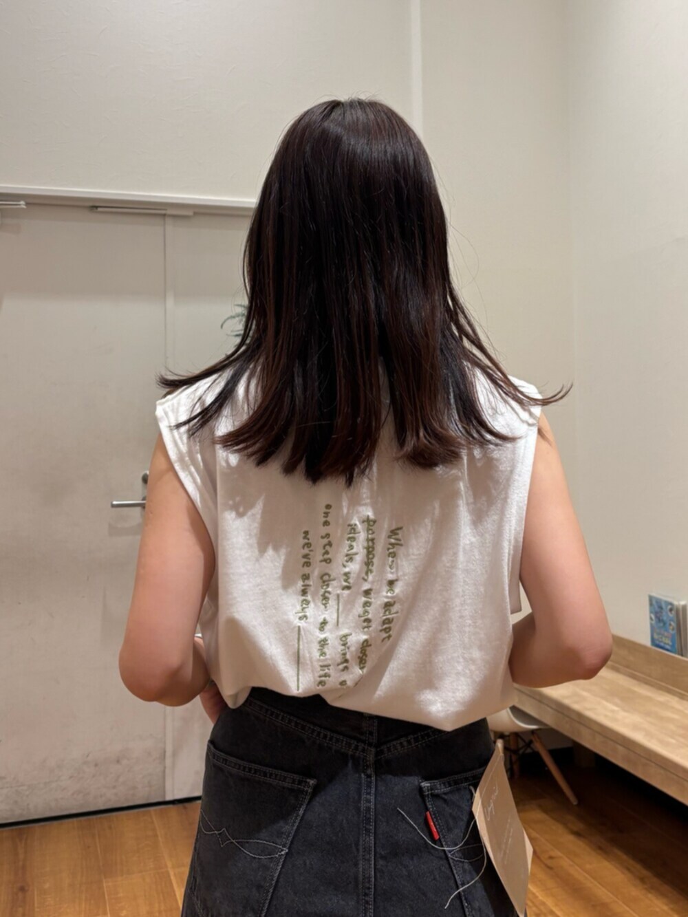 ホワイト系のタンクトップ、ブラック系のデニムパンツ、ホワイト系のサンダルを着用したレディースの夏コーディネートの7枚目の写真