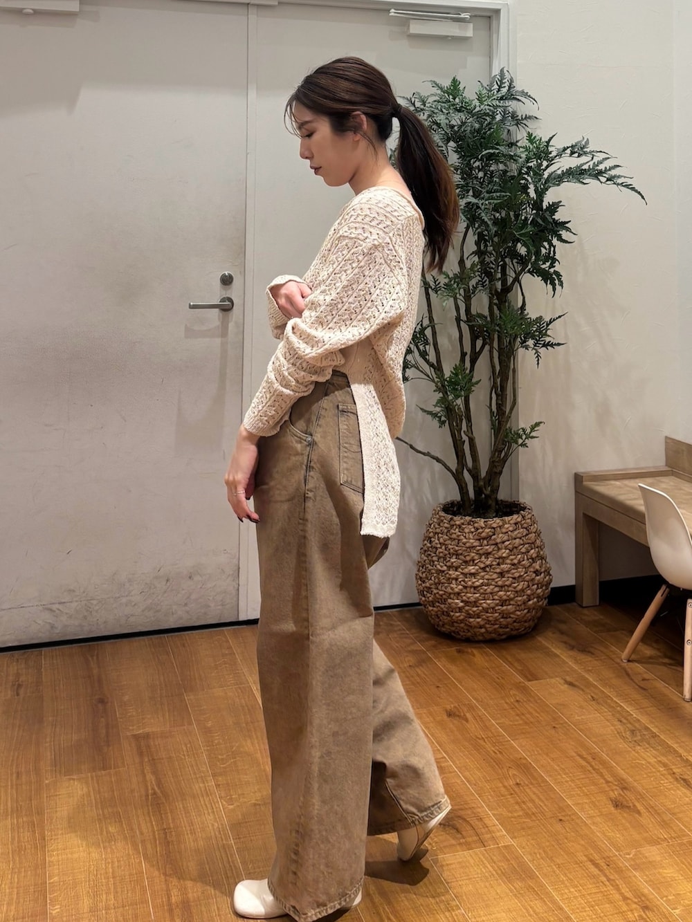 ベージュ系のニット/セーター、ブラウン系のデニムパンツを着用したレディースの春コーディネートの3枚目の写真