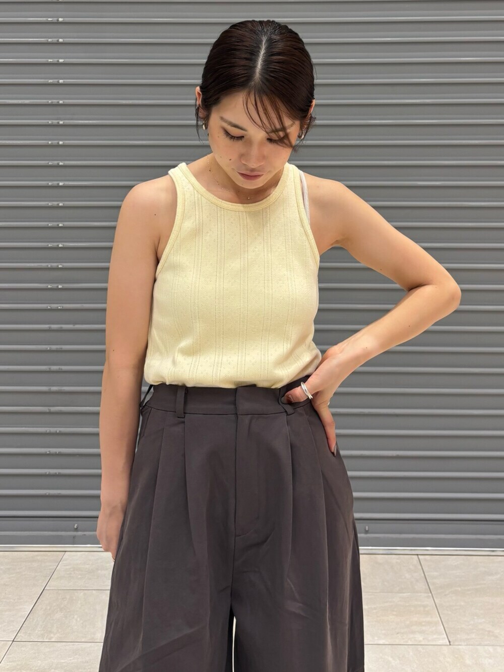 シルバー系のサンダル、イエロー系のタンクトップ、グレー系のチノパンツを着用したレディースの夏コーディネートの5枚目の写真