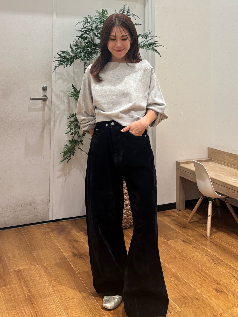 グレー系のスウェット、ブラック系のデニムパンツを着用したレディースの秋コーディネートの2枚目の写真