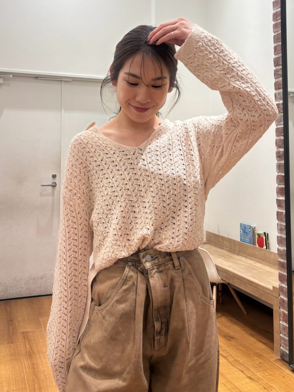 ベージュ系のニット/セーター、ブラウン系のデニムパンツを着用したレディースの春コーディネートの5枚目の写真