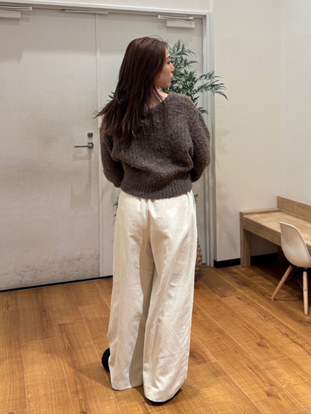ブラウン系のカーディガン/ボレロ、ホワイト系のその他パンツ、ブラック系のスリッポンを着用したレディースの冬コーディネートの4枚目の写真