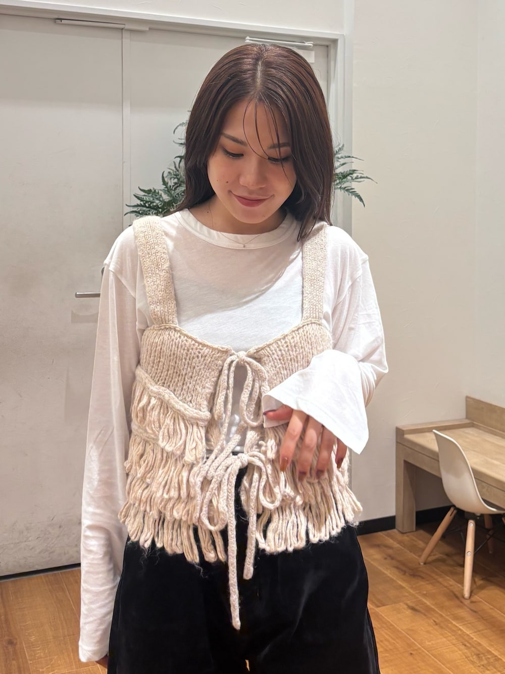 ホワイト系のTシャツ/カットソー、ホワイト系のニット/セーター、ブラック系のデニムパンツを着用したレディースの秋コーディネートの5枚目の写真