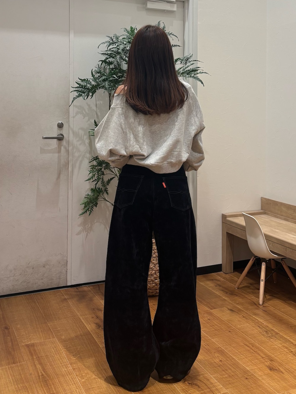 グレー系のスウェット、ブラック系のデニムパンツを着用したレディースの秋コーディネートの4枚目の写真