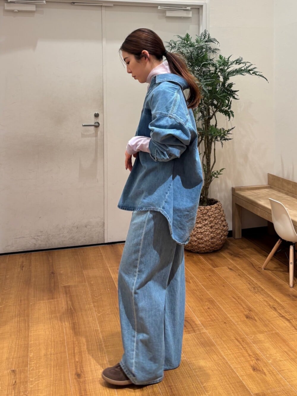 ブルー系のシャツ/ブラウス、ブルー系のデニムパンツ、パープル系のTシャツ/カットソーを着用したレディースの春コーディネートの3枚目の写真