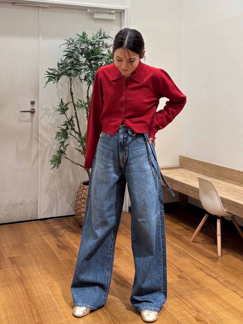 レッド系のカーディガン/ボレロ、ブルー系のデニムパンツ、ゴールド系のバレエシューズを着用したレディースの秋コーディネートの2枚目の写真