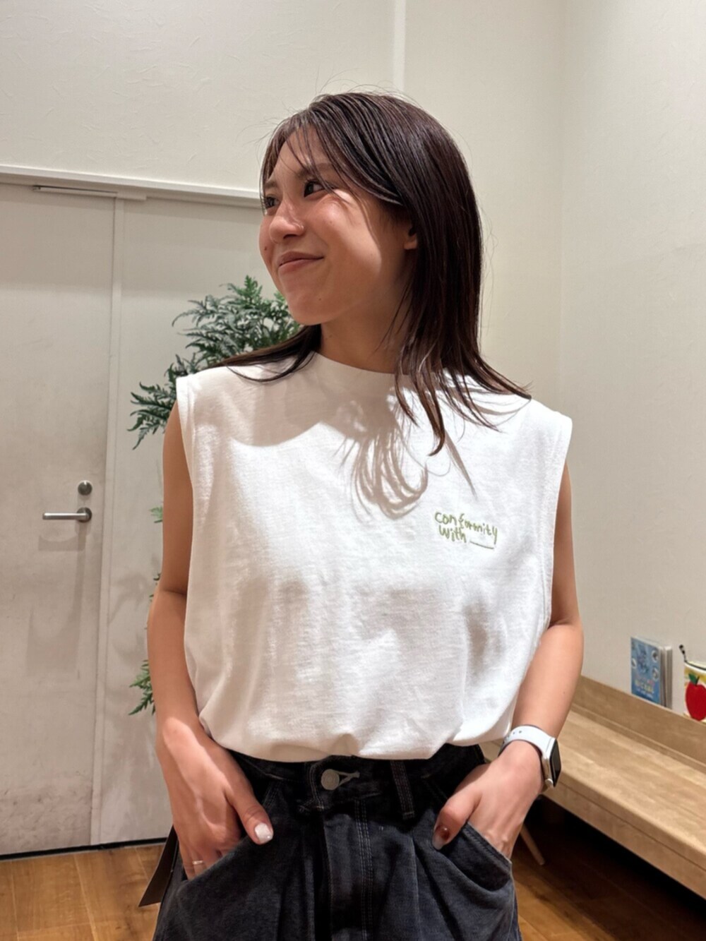 ホワイト系のタンクトップ、ブラック系のデニムパンツ、ホワイト系のサンダルを着用したレディースの夏コーディネートの5枚目の写真