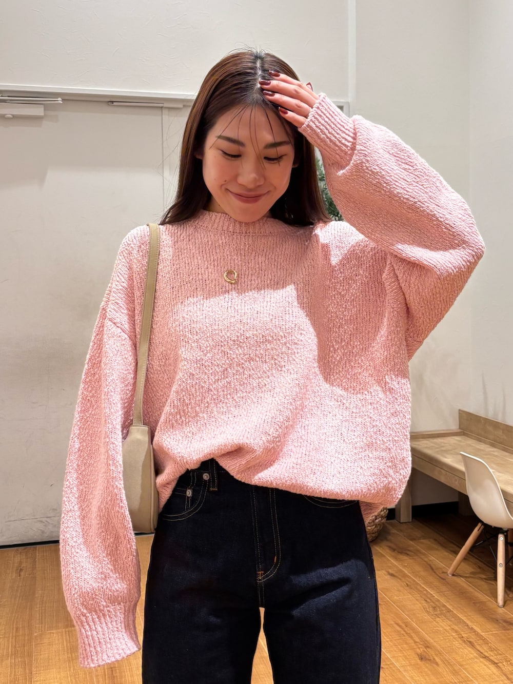 ピンク系のニット/セーター、ブルー系のデニムパンツを着用したレディースの冬コーディネートの5枚目の写真