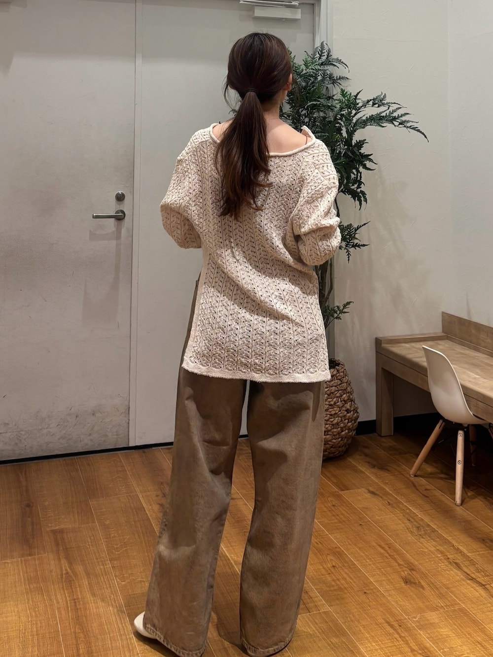 ベージュ系のニット/セーター、ブラウン系のデニムパンツを着用したレディースの春コーディネートの4枚目の写真