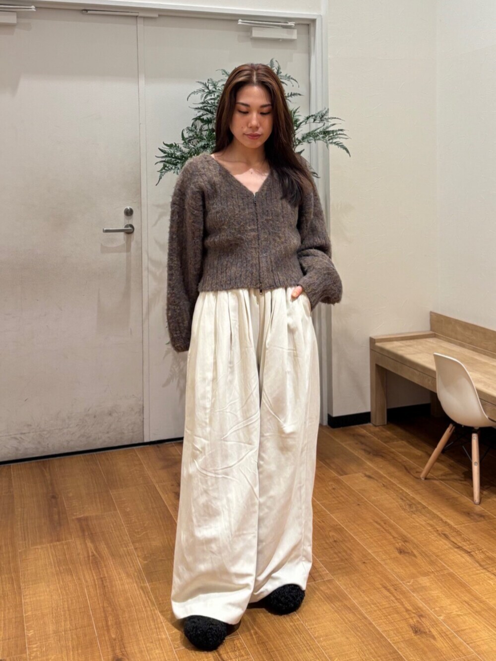 ブラウン系のカーディガン/ボレロ、ホワイト系のその他パンツ、ブラック系のスリッポンを着用したレディースの冬コーディネートの2枚目の写真