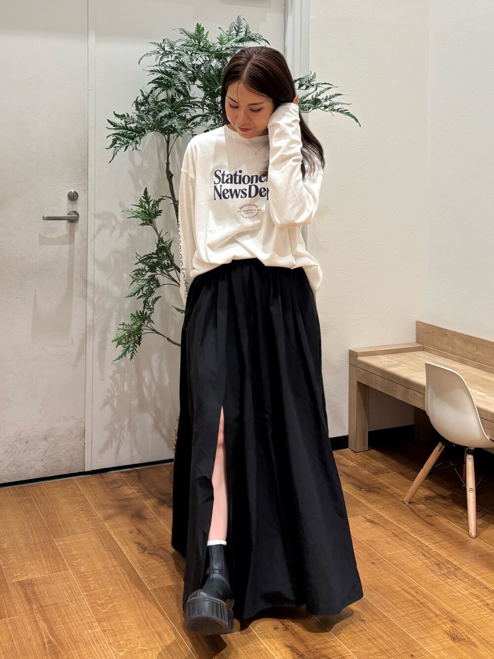 ホワイト系のTシャツ/カットソー、ブラック系のスカートを着用したレディースの秋コーディネートの2枚目の写真