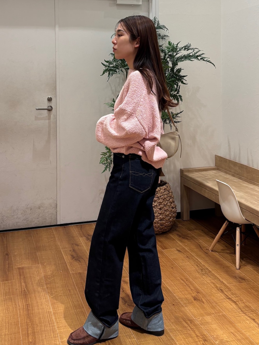 ピンク系のニット/セーター、ブルー系のデニムパンツを着用したレディースの冬コーディネートの2枚目の写真