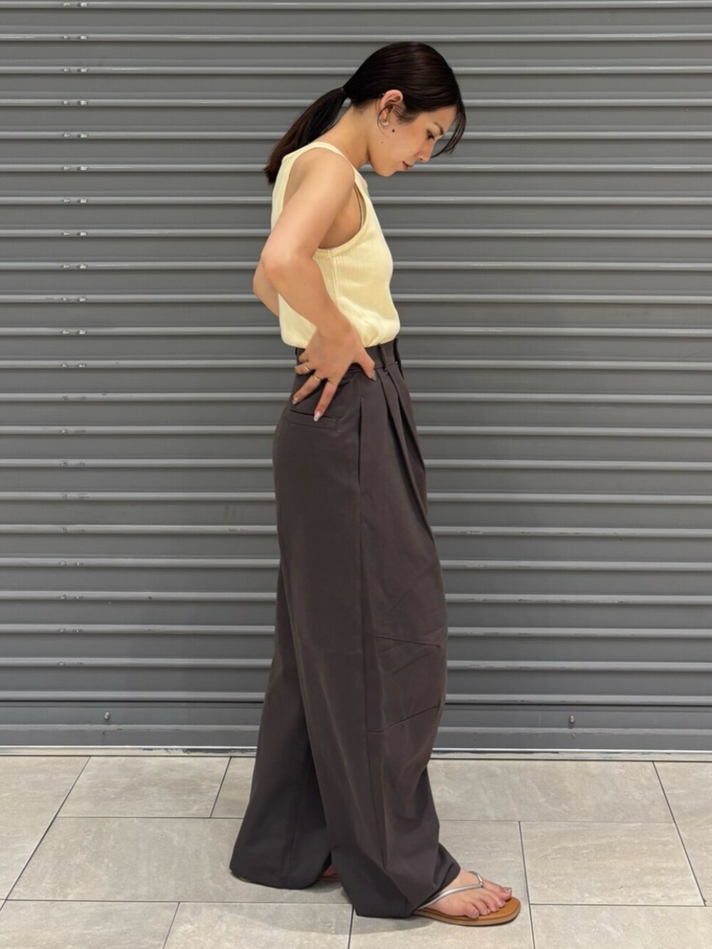 シルバー系のサンダル、イエロー系のタンクトップ、グレー系のチノパンツを着用したレディースの夏コーディネートの3枚目の写真