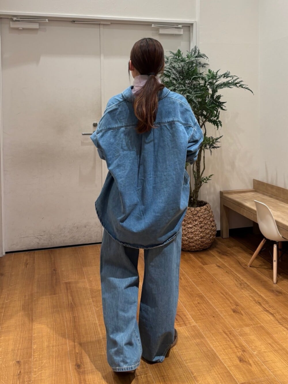 ブルー系のシャツ/ブラウス、ブルー系のデニムパンツ、パープル系のTシャツ/カットソーを着用したレディースの春コーディネートの4枚目の写真