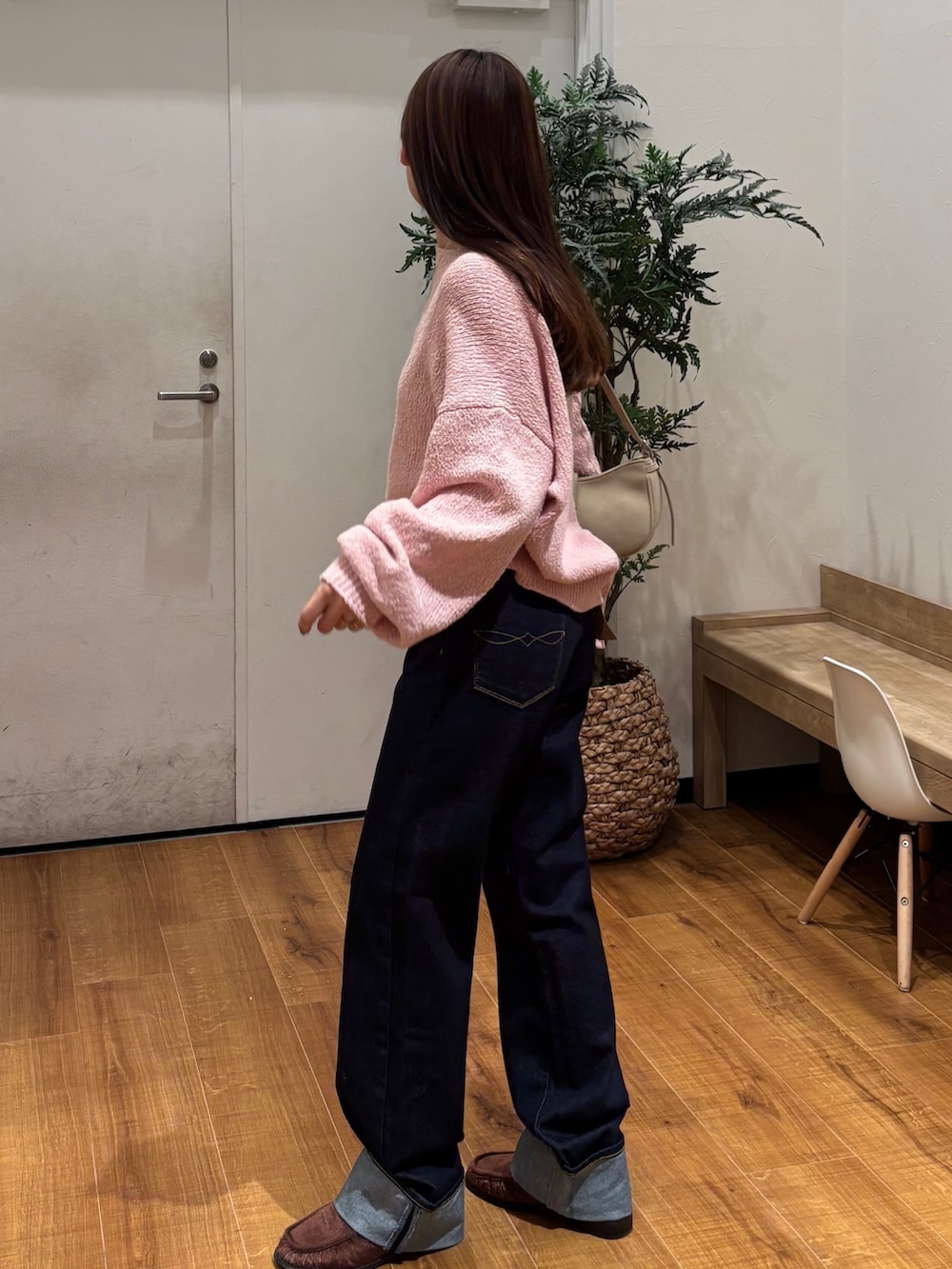 ピンク系のニット/セーター、ブルー系のデニムパンツを着用したレディースの冬コーディネートの3枚目の写真