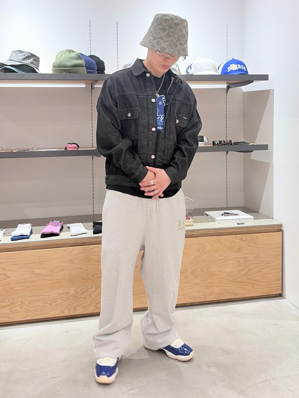 グレー系のスウェットパンツ、ブラック系のデニムジャケット、グレー系のハットを着用したメンズの春コーディネートの2枚目の写真