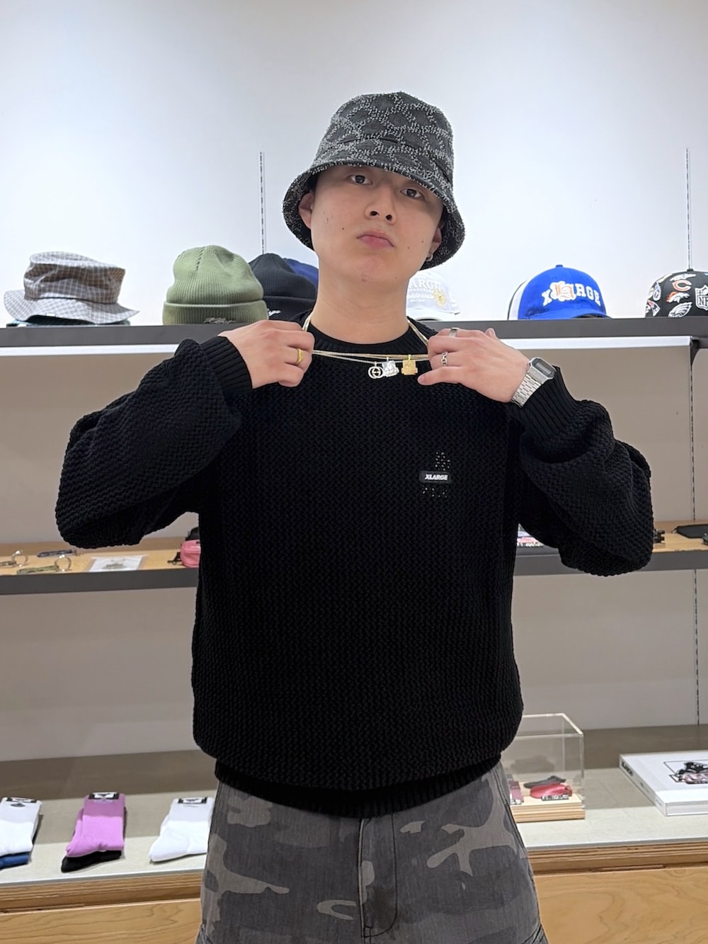 ブラック系のニット/セーター、ブラック系のカーゴパンツ、ブラック系のハットを着用したメンズの春コーディネートの5枚目の写真