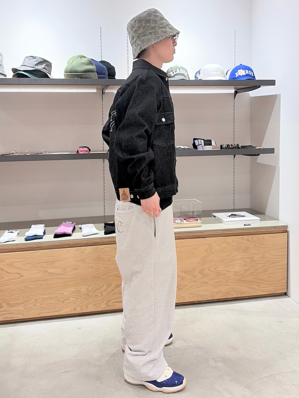 グレー系のスウェットパンツ、ブラック系のデニムジャケット、グレー系のハットを着用したメンズの春コーディネートの3枚目の写真