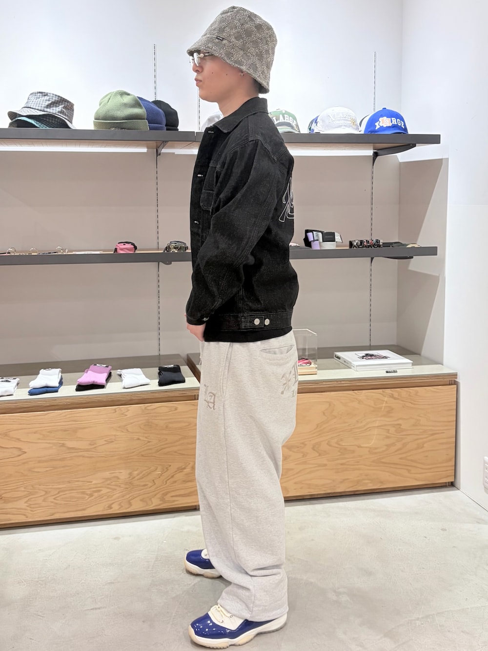 グレー系のスウェットパンツ、ブラック系のデニムジャケット、グレー系のハットを着用したメンズの春コーディネートの5枚目の写真