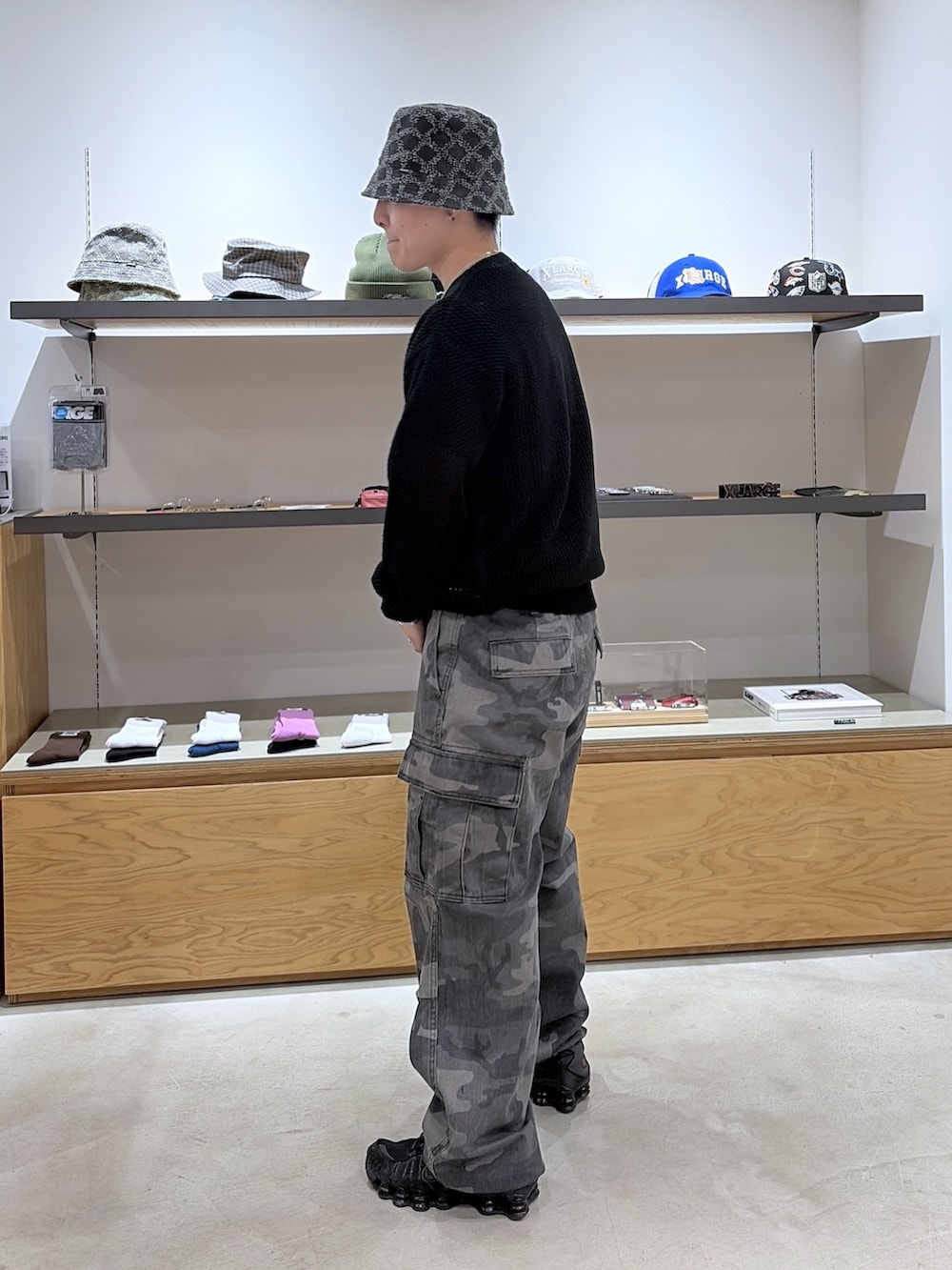 ブラック系のニット/セーター、ブラック系のカーゴパンツ、ブラック系のハットを着用したメンズの春コーディネートの4枚目の写真