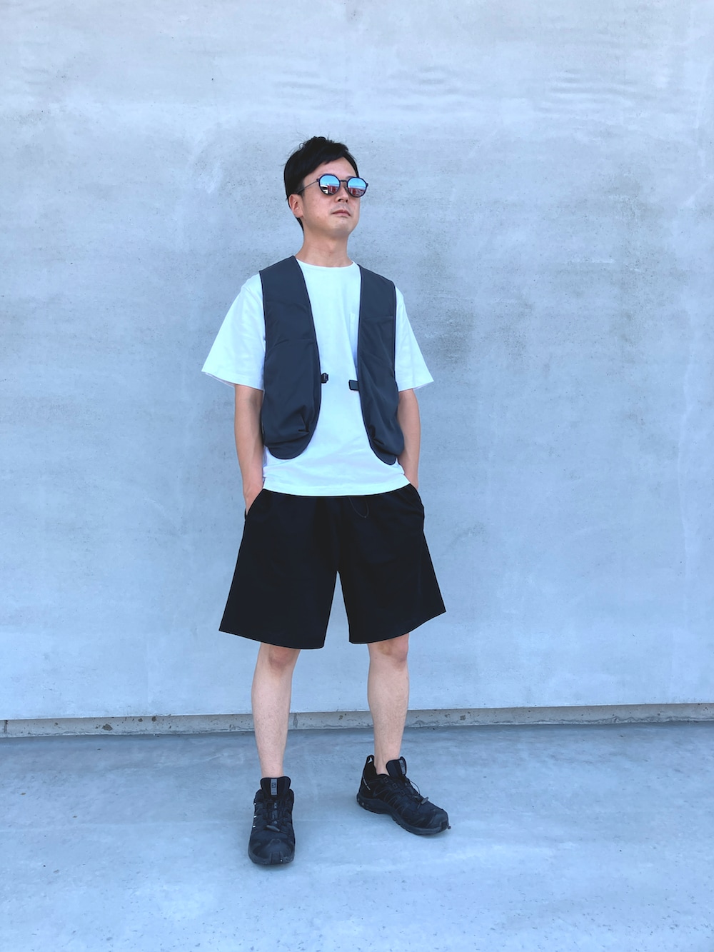 グレー系のベスト、ホワイト系のTシャツ/カットソー、ブラック系のTシャツ/カットソーを着用したメンズの夏コーディネートの2枚目の写真