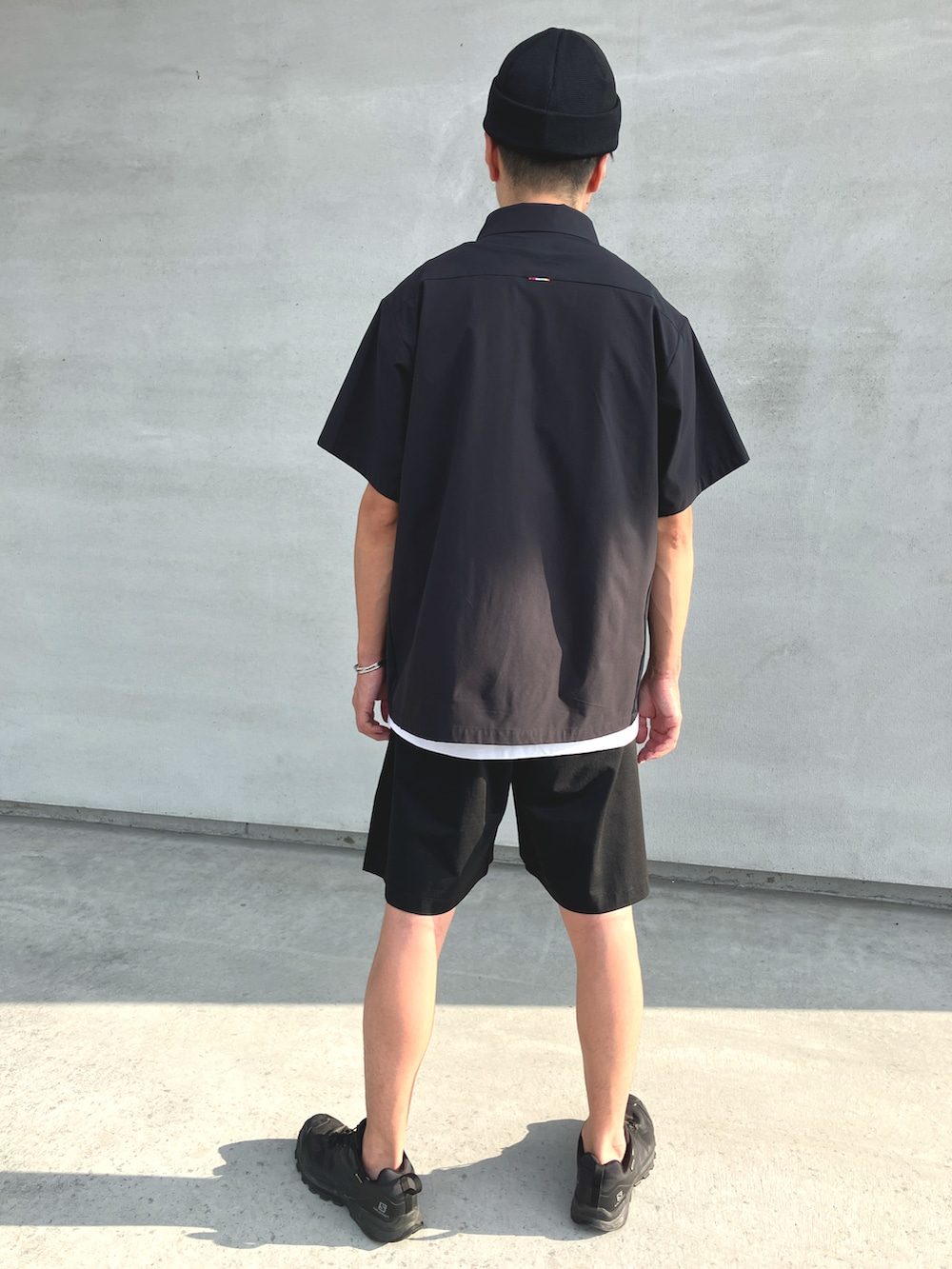 ブラック系のTシャツ/カットソー、ブラック系のスニーカー、ホワイト系のタンクトップを着用したメンズの秋コーディネートの3枚目の写真