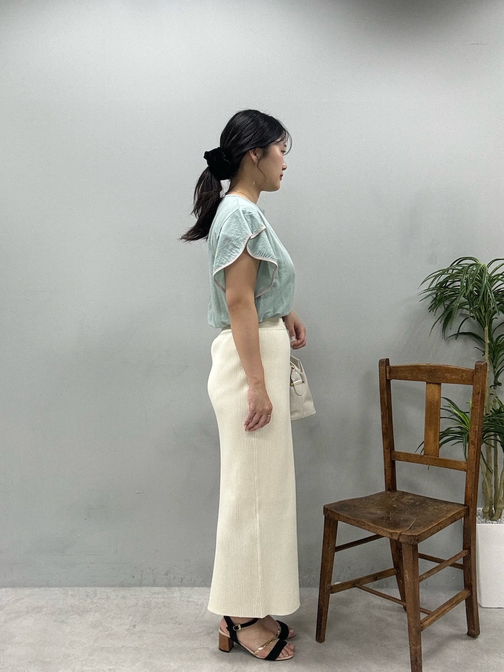 ホワイト系のショルダーバッグ、グリーン系のTシャツ/カットソー、ホワイト系のスカートを着用したレディースの春コーディネートの4枚目の写真