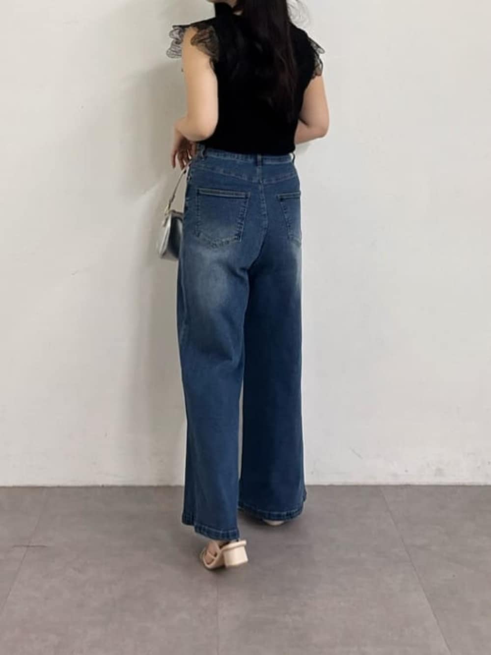 ブルー系のデニムパンツ、ブラック系のニット/セーターを着用したレディースの夏コーディネートの4枚目の写真