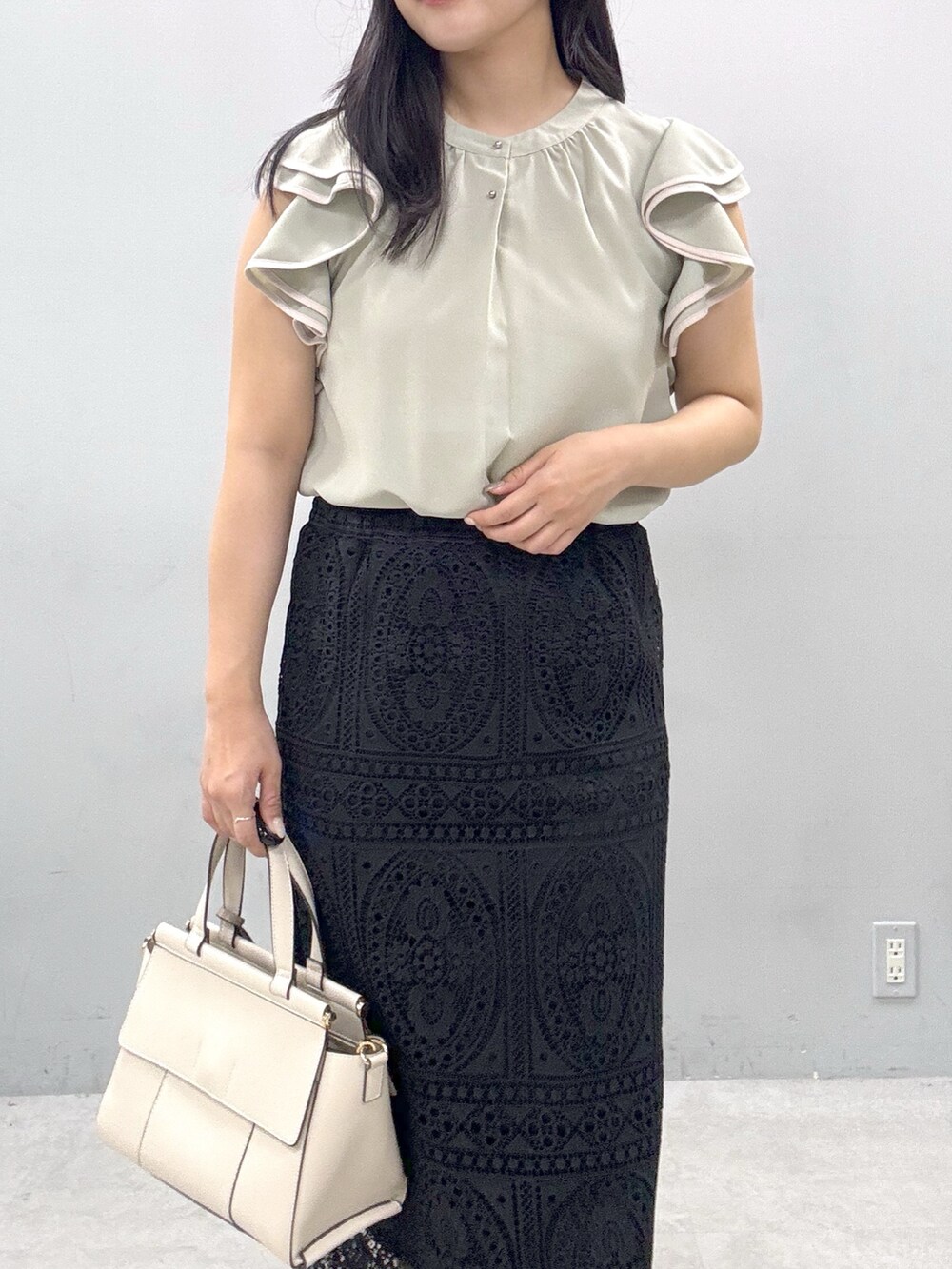 ブラック系のスカート、グリーン系のシャツ/ブラウスを着用したレディースの春コーディネートの4枚目の写真