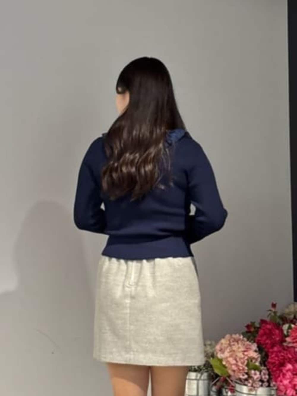 グレー系のスカート、ブルー系のニット/セーターを着用したレディースの冬コーディネートの3枚目の写真