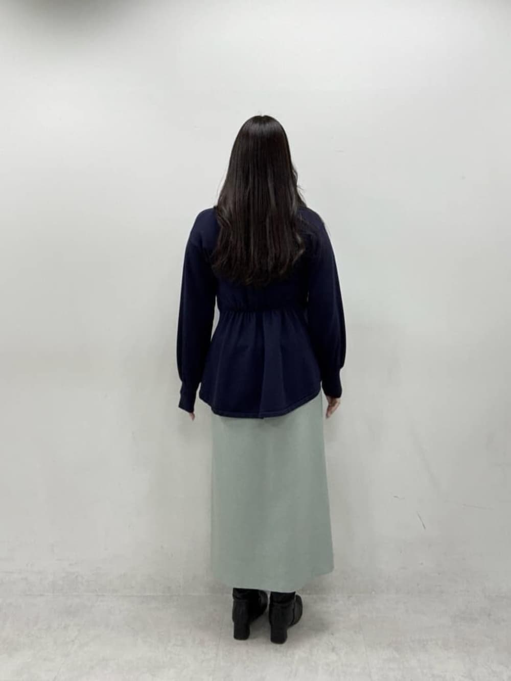 グリーン系のスカート、ブルー系のニット/セーターを着用したレディースの冬コーディネートの3枚目の写真