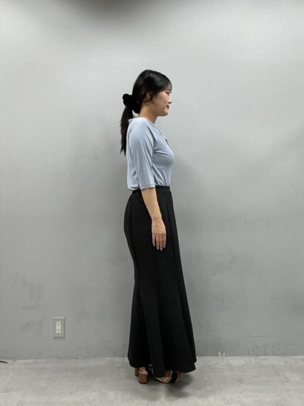 ブラック系のスカート、ブルー系のTシャツ/カットソーを着用したレディースの夏コーディネートの2枚目の写真