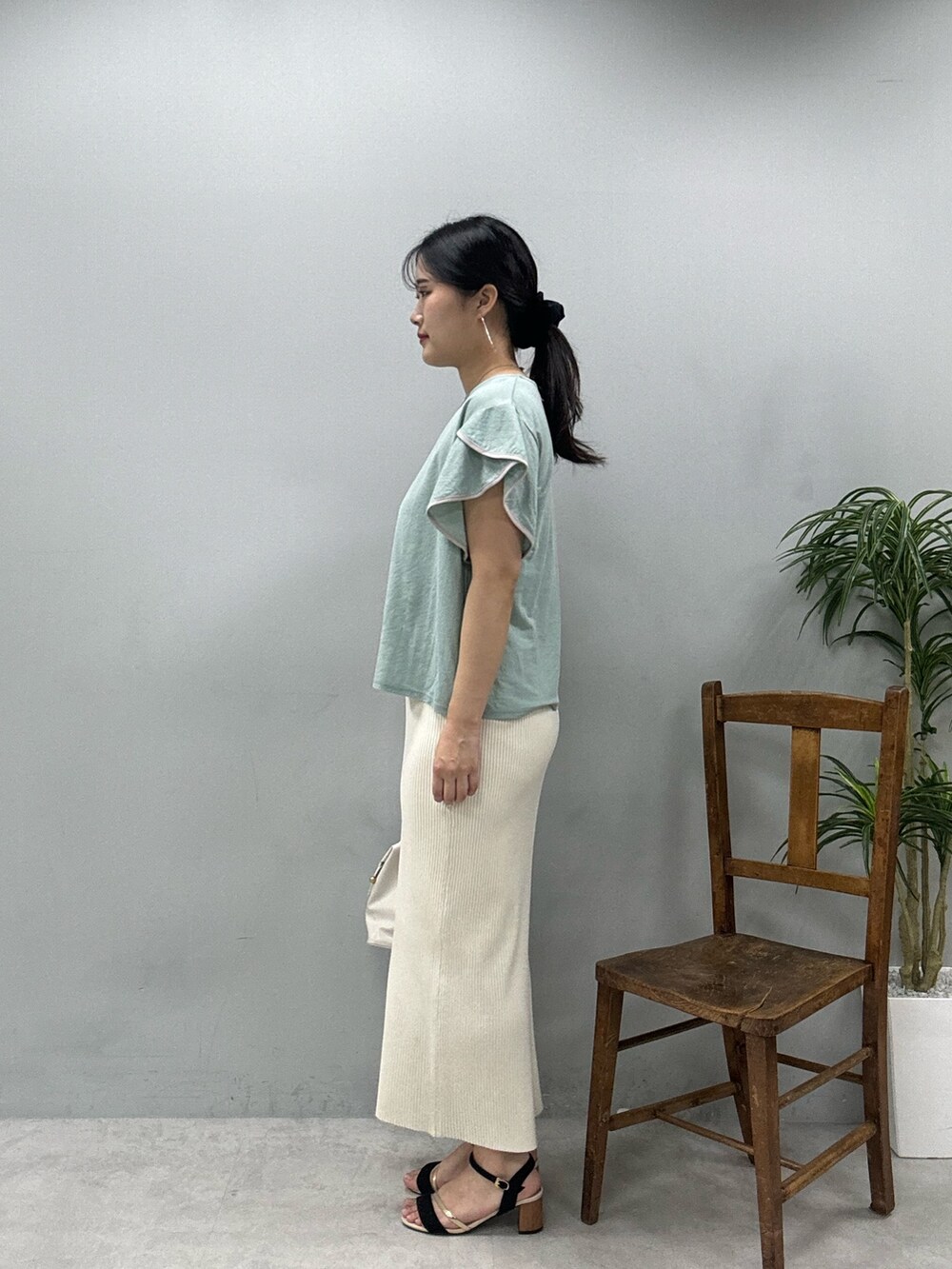 ホワイト系のショルダーバッグ、グリーン系のTシャツ/カットソー、ホワイト系のスカートを着用したレディースの春コーディネートの3枚目の写真