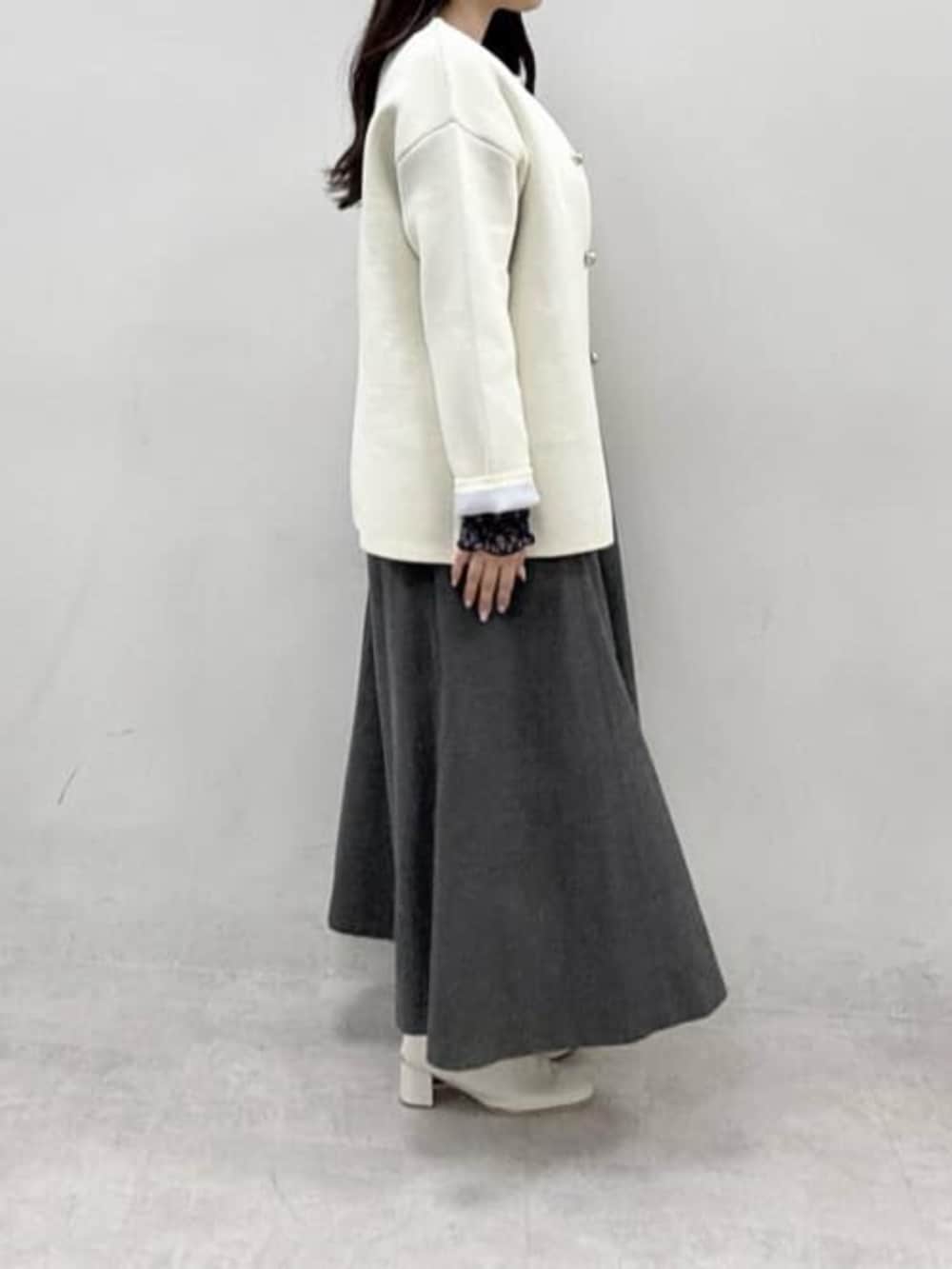 ホワイト系のカーディガン/ボレロ、ブルー系のTシャツ/カットソー、グレー系のスカートを着用したレディースの冬コーディネートの2枚目の写真