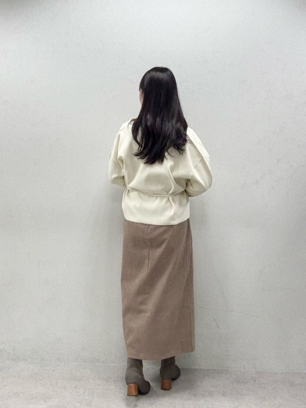 ブラウン系のスカート、グレー系のTシャツ/カットソー、ホワイト系のカーディガン/ボレロを着用したレディースの秋コーディネートの3枚目の写真