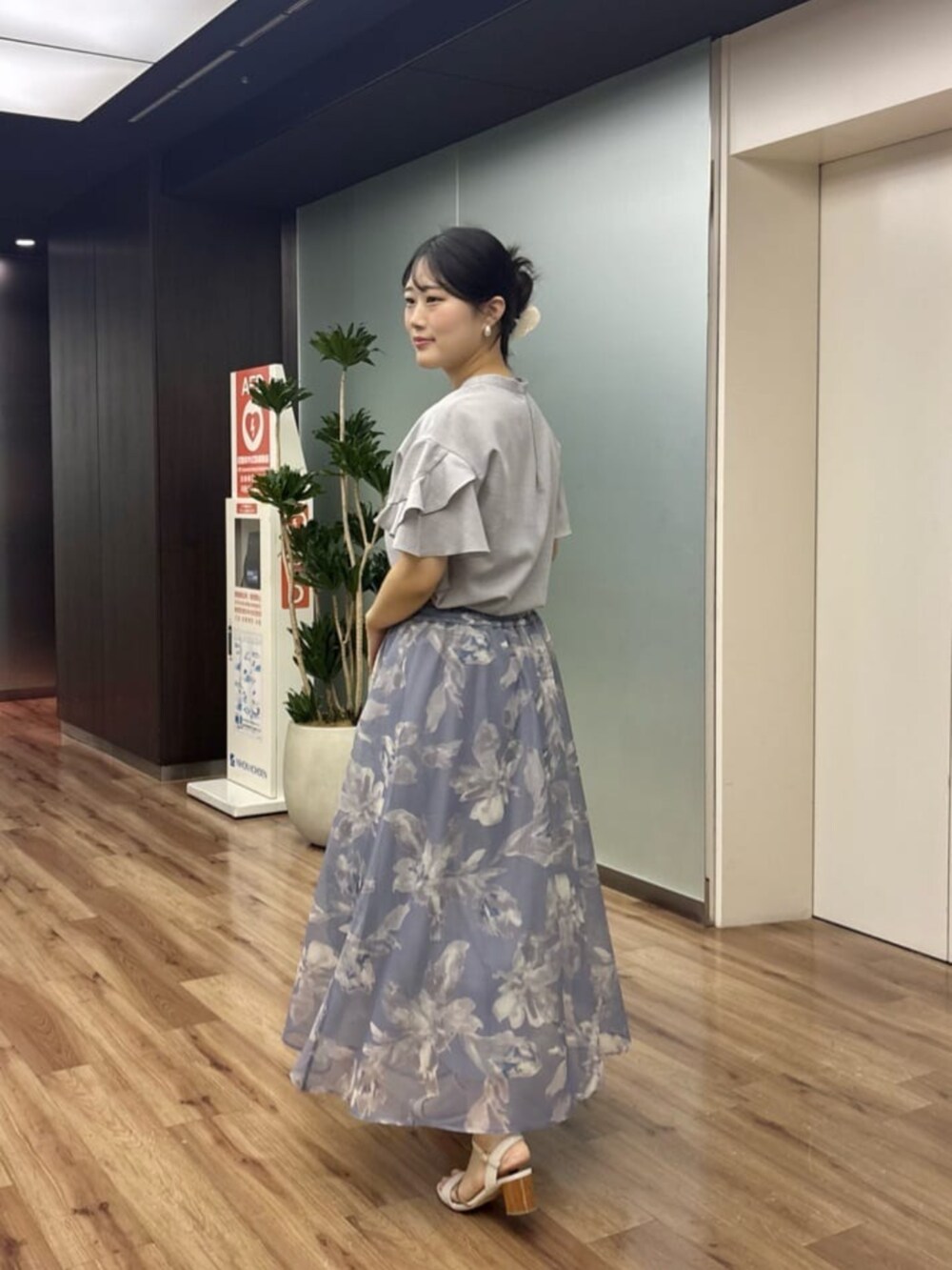 グレー系のシャツ/ブラウス、ブラック系のボストンバッグ、ブルー系のスカートを着用したレディースの夏コーディネートの3枚目の写真