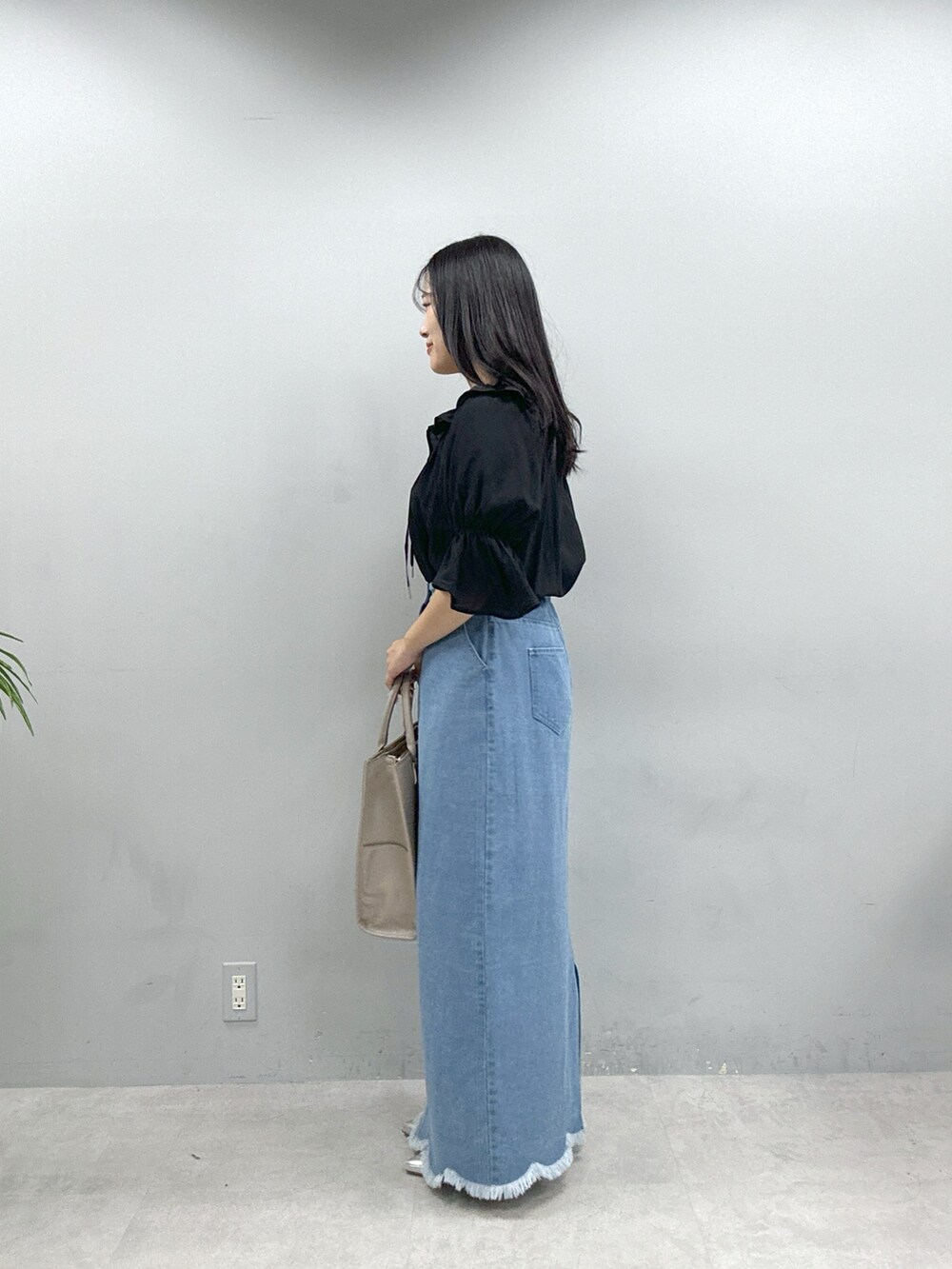 ベージュ系のショルダーバッグ、ブラック系のシャツ/ブラウス、ブルー系のスカートを着用したレディースの春コーディネートの3枚目の写真