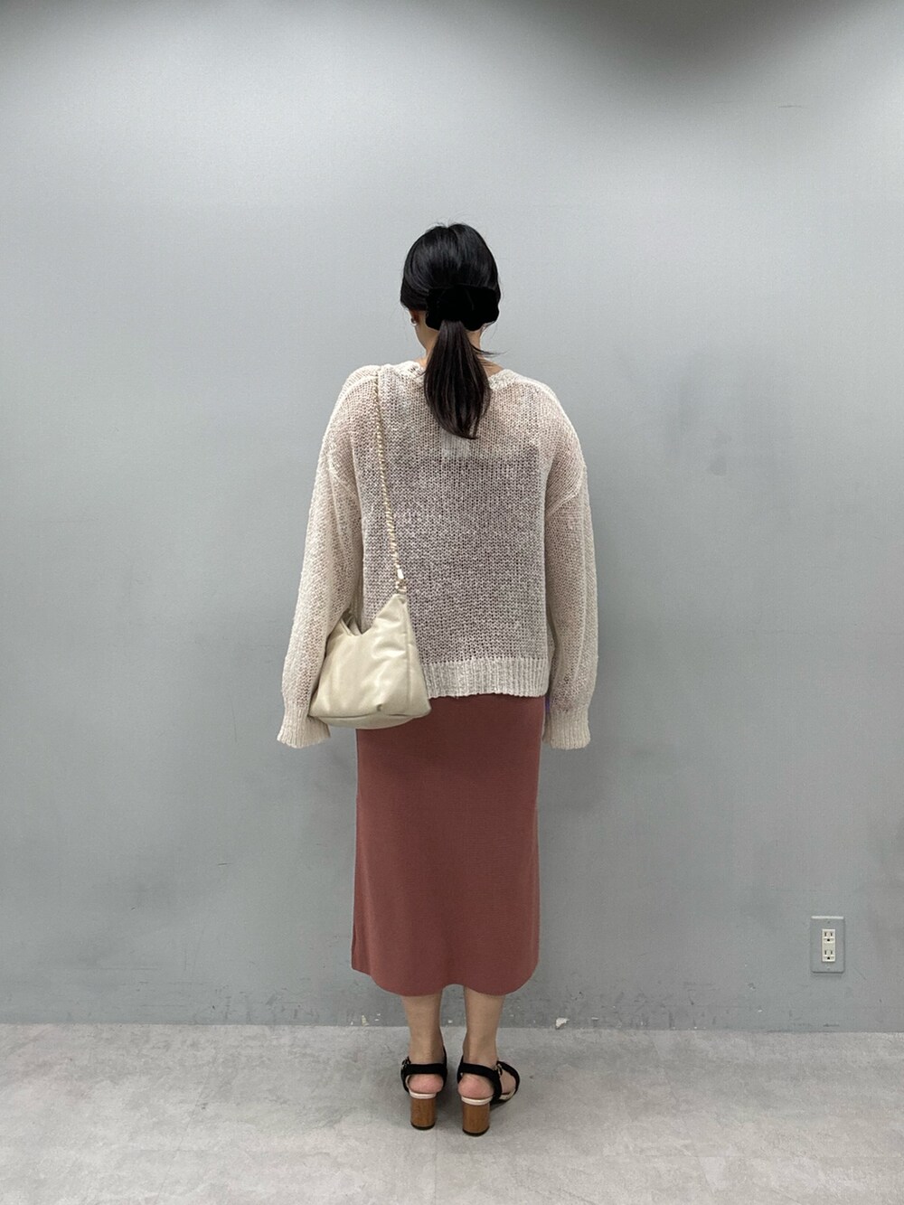 レッド系のワンピース、ホワイト系のカーディガン/ボレロを着用したレディースの春コーディネートの3枚目の写真
