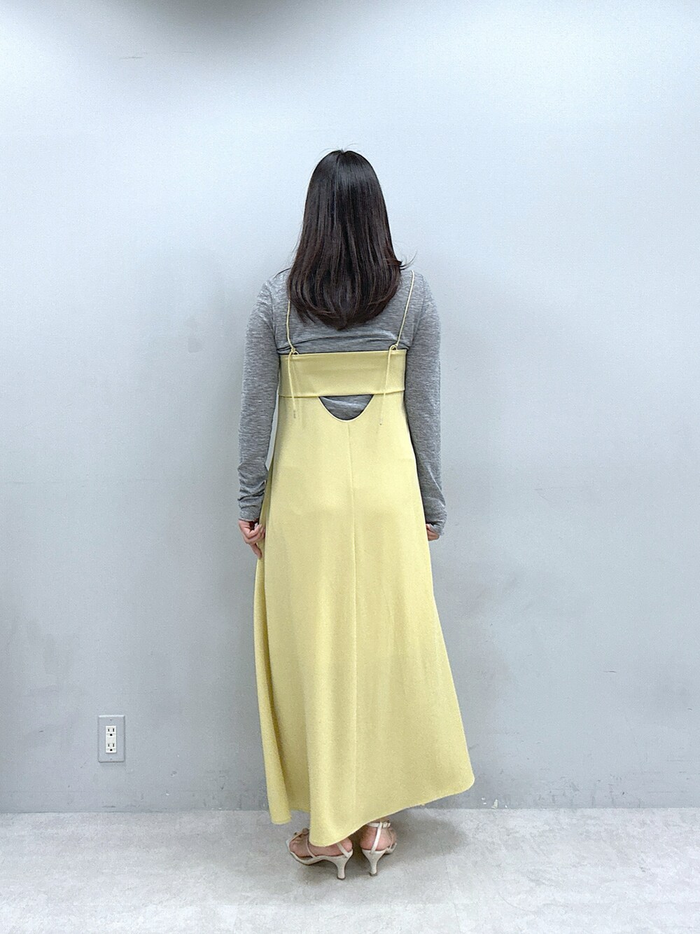 イエロー系のワンピース、グレー系のTシャツ/カットソーを着用したレディースの春コーディネートの3枚目の写真