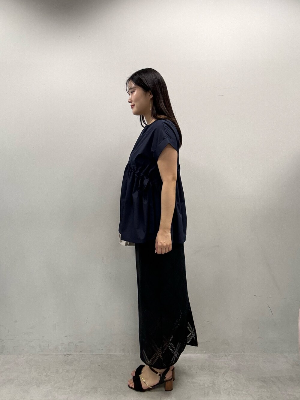 ホワイト系のショルダーバッグ、ブルー系のシャツ/ブラウス、ブラック系のスカートを着用したレディースの春コーディネートの2枚目の写真