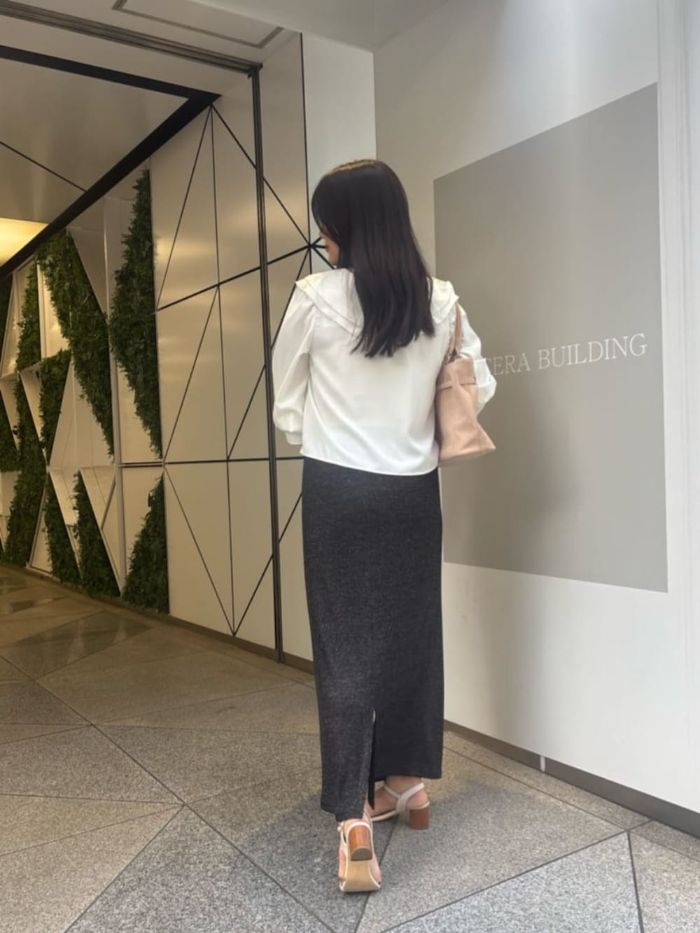 ブラック系のスカート、ホワイト系のシャツ/ブラウスを着用したレディースの夏コーディネートの2枚目の写真