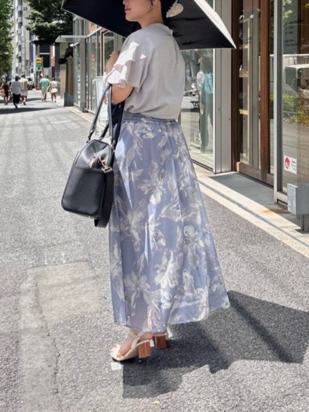 グレー系のシャツ/ブラウス、ブラック系のボストンバッグ、ブルー系のスカートを着用したレディースの夏コーディネートの2枚目の写真