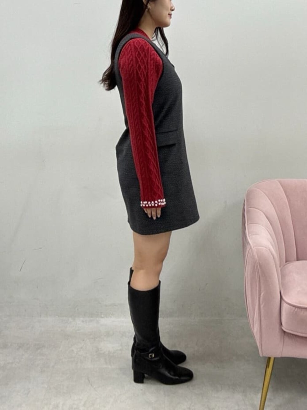 グレー系のワンピース、レッド系のニット/セーターを着用したレディースの冬コーディネートの2枚目の写真