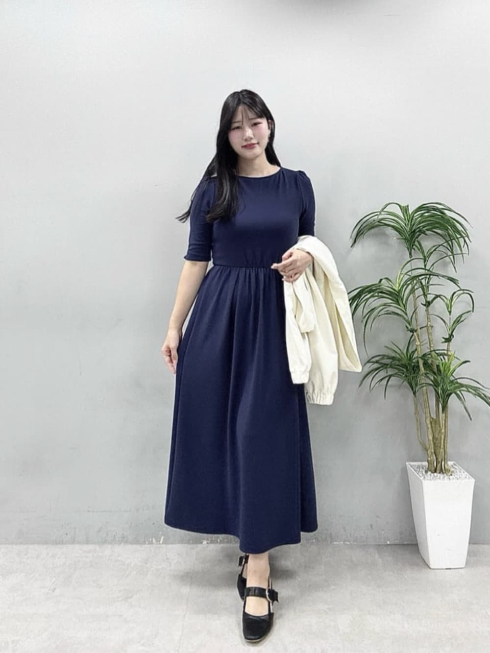 ホワイト系のマウンテンパーカー、ブルー系のワンピースを着用したレディースの春コーディネートの2枚目の写真