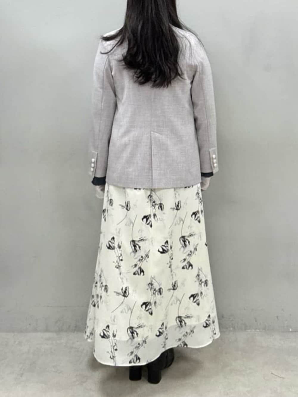 ホワイト系のスカート、グレー系のテーラードジャケット、グレー系のTシャツ/カットソーを着用したレディースの冬コーディネートの3枚目の写真