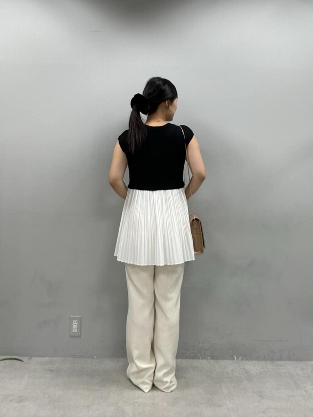 ベージュ系のショルダーバッグ、ホワイト系のその他パンツ、ブラック系のニット/セーターを着用したレディースの夏コーディネートの3枚目の写真