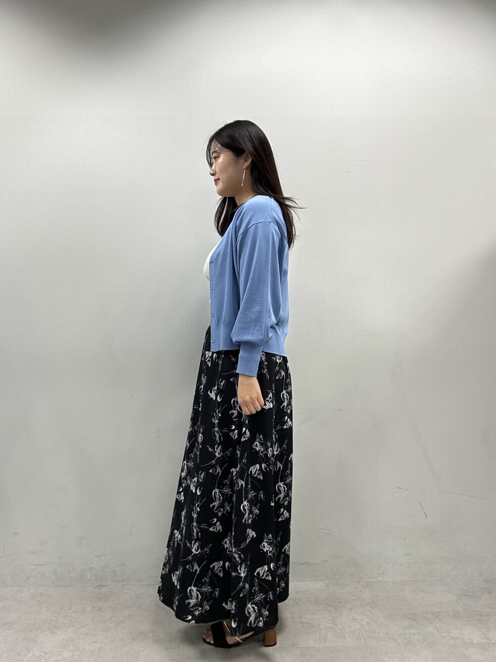 ブルー系のカーディガン/ボレロ、ブラック系のスカート、ホワイト系のニット/セーターを着用したレディースの春コーディネートの2枚目の写真