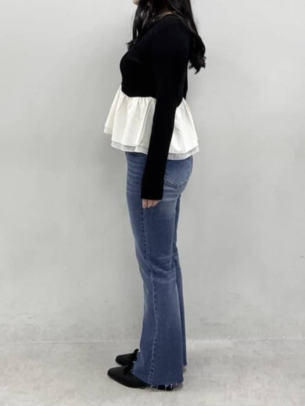 ブラック系のニット/セーター、ブルー系のデニムパンツ、ブラック系のその他シューズを着用したレディースの冬コーディネートの2枚目の写真