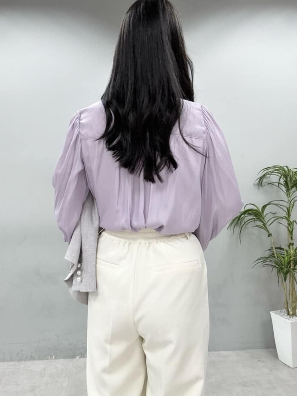 ホワイト系のハンドバッグ、パープル系のシャツ/ブラウス、ホワイト系のスラックスを着用したレディースの冬コーディネートの5枚目の写真