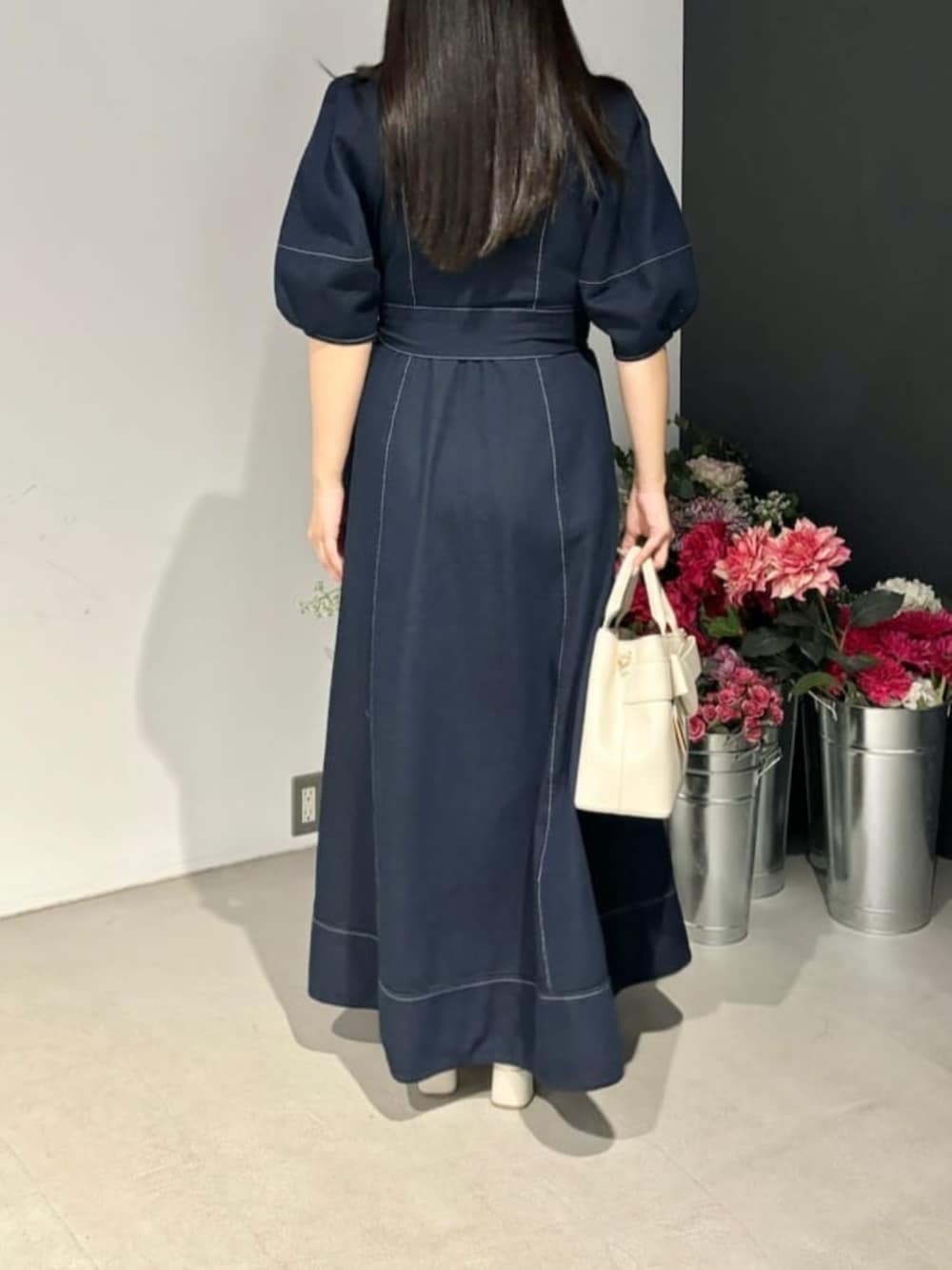 ブルー系のワンピース、ホワイト系のショルダーバッグを着用したレディースの冬コーディネートの3枚目の写真